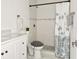 This bathroom features a modern white vanity, toilet, and shower with a decorative shower curtain at 5118 Tennis Court Circle, Tampa, FL 33617