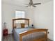 This bedroom has a wooden bed frame, a checkered blanket and natural light from a large window at 5118 Tennis Court Circle, Tampa, FL 33617