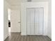 Hallway featuring a closet with folding doors, wood floors, and doorways to the bedrooms at 5118 Tennis Court Circle, Tampa, FL 33617