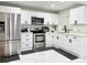Updated kitchen with stainless steel appliances, white cabinets, and black accents at 5118 Tennis Court Circle, Tampa, FL 33617