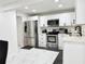 Modern kitchen with stainless steel appliances, white cabinetry, and tile flooring at 5118 Tennis Court Circle, Tampa, FL 33617