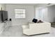 Living room featuring tile floors, a white sectional, and a large window at 5118 Tennis Court Circle, Tampa, FL 33617