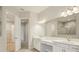 Bright bathroom with dual sinks, white cabinets, and a large mirror at 5152 Wildwind Dr, Apollo Beach, FL 33572