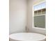 Bright bathroom featuring a modern soaking tub near a large window at 5152 Wildwind Dr, Apollo Beach, FL 33572