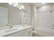 Bathroom with dual sink vanity, white cabinets, and a shower tub at 5152 Wildwind Dr, Apollo Beach, FL 33572