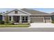 Beautiful home with a three car garage, elegant landscaping, and a cozy front porch at 5152 Wildwind Dr, Apollo Beach, FL 33572