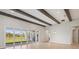Open living room has wooden beams, light wood floors, and large sliding glass doors at 5152 Wildwind Dr, Apollo Beach, FL 33572