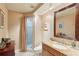 The bathroom has wallpapered walls, a beautiful mirror, and a glass shower with a shower curtain at 5335 Sand Crane Ct, Wesley Chapel, FL 33543