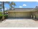 Attached two-car garage with a concrete driveway and mature landscaping at 5335 Sand Crane Ct, Wesley Chapel, FL 33543