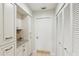 Bright hallway featuring white cabinets with granite countertop and a door with louvered closet doors at 5335 Sand Crane Ct, Wesley Chapel, FL 33543
