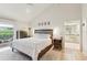 Bright main bedroom featuring an ensuite bathroom, hardwood floors, and natural light at 5335 Sand Crane Ct, Wesley Chapel, FL 33543