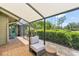 Screened patio with lounge chair and view of a well manicured lawn and garden at 5335 Sand Crane Ct, Wesley Chapel, FL 33543