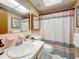 Cozy bathroom with a classic sink and vanity, tiled walls, and a patterned shower curtain at 5890 38Th N Ave # 305, St Petersburg, FL 33710