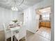 Dining room with sleek white table set and modern chandelier, adjacent to the kitchen at 5890 38Th N Ave # 305, St Petersburg, FL 33710