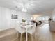 Dining room with sleek white table, seating for six, and a modern chandelier at 5890 38Th N Ave # 305, St Petersburg, FL 33710