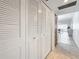 Hallway with utility closet with louvered doors and access to a living area featuring neutral flooring and lighting at 5890 38Th N Ave # 305, St Petersburg, FL 33710