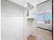 A light and bright walk-in closet with shelving, hanging rods, and wood-look vinyl flooring provides ample storage at 5890 38Th N Ave # 305, St Petersburg, FL 33710