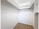 This is a spacious walk-in closet with a skylight, white walls, and wood-look vinyl flooring for a modern look at 5890 38Th N Ave # 305, St Petersburg, FL 33710
