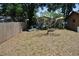 Spacious backyard with mature trees, green lawn, wooden fence, and patio furniture at 601 W College Ave, Ruskin, FL 33570