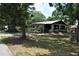 Charming single-story home with a covered front porch and mature trees surrounding the property at 601 W College Ave, Ruskin, FL 33570