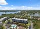 Beautiful aerial view of condo community by the water, featuring a pool, green landscape and clear blue sky at 6205 Shoreline Dr # 1204, St Petersburg, FL 33708