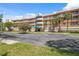 Three-story condo building showing neutral exterior with balconies, a blue awning and palm trees in Florida at 6205 Shoreline Dr # 1204, St Petersburg, FL 33708