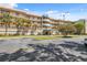 Condominium complex featuring a well-maintained lawn, palm trees, and a clear sky at 6205 Shoreline Dr # 1204, St Petersburg, FL 33708