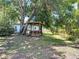 Backyard featuring covered swing set area surrounded by mature trees at 6350 55Th N Ave, St Petersburg, FL 33709