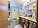 Well-lit bathroom featuring double sinks, stylish wallpaper, and a window over the bathtub at 6350 55Th N Ave, St Petersburg, FL 33709