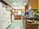 Efficient kitchen layout featuring wood cabinets, a white refrigerator and plenty of counter space at 6350 55Th N Ave, St Petersburg, FL 33709