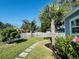 Landscaped front yard with palm trees, manicured lawn, and a charming picket fence at 6401 30Th N Way, St Petersburg, FL 33702