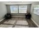 Inviting living room with modern gray flooring, a cozy armchair, and plenty of sunlight streaming through the windows at 6401 30Th N Way, St Petersburg, FL 33702