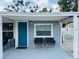 Cozy covered porch with two chairs, a large window, and a charming blue front door at 6401 30Th N Way, St Petersburg, FL 33702