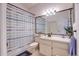 Bathroom with a large mirror, striped shower curtain, and neutral-toned vanity at 6410 Beaver Way, Tampa, FL 33625