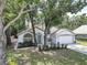 Charming single Gathering home featuring mature trees and a well maintained front yard at 6410 Beaver Way, Tampa, FL 33625
