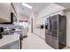 Bright kitchen features a stainless steel refrigerator, white cabinets, and tile flooring at 6410 Beaver Way, Tampa, FL 33625