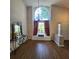 Bright living room featuring hardwood floors, chandelier and tall arched window at 6410 Beaver Way, Tampa, FL 33625