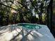 Relaxing screened-in pool area with a kidney-shaped pool and surrounding trees at 6410 Beaver Way, Tampa, FL 33625