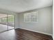 Bright and spacious bedroom featuring wood floors, large window, and a sliding glass door to the outside at 7280 Tarrytown Dr, Spring Hill, FL 34606
