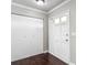 Bright foyer featuring a closet with white doors, dark wood floors, and a paneled interior door at 7280 Tarrytown Dr, Spring Hill, FL 34606