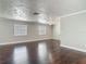Unfurnished living area showcasing dark wood floors, neutral walls, and abundant natural light through windows at 7280 Tarrytown Dr, Spring Hill, FL 34606