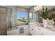 Bright bathroom boasts double vanity, a soaking tub, separate shower, and a large window with a view at 733 Sky Shade Dr, Apollo Beach, FL 33572
