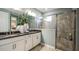 Bathroom featuring double vanity with gray counters and a glass-enclosed tiled shower at 733 Sky Shade Dr, Apollo Beach, FL 33572