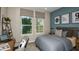 bedroom featuring a gray bed, blue accent wall, and desk area with natural light at 733 Sky Shade Dr, Apollo Beach, FL 33572