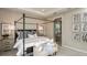 Elegant main bedroom with a four poster bed and soft textures and ensuite bath with glass shower at 733 Sky Shade Dr, Apollo Beach, FL 33572