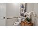 Powder room with grab bars, decorative art, and a floral arrangement on a wooden cabinet at 733 Sky Shade Dr, Apollo Beach, FL 33572