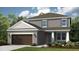 Charming two-story home with gray siding, a two-car garage, and beautifully landscaped front yard at 735 Sky Shade Dr, Apollo Beach, FL 33572