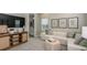 Inviting living room featuring a cream sofa, woven console, television and natural light at 735 Sky Shade Dr, Apollo Beach, FL 33572