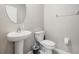 Elegant powder room with a pedestal sink, round mirror, and modern fixtures, providing a functional space for guests at 754 8Th Nw St, Ruskin, FL 33570