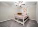 Well-lit bedroom featuring a white bed frame, a colorful curtain, and neutral paint for a cozy and relaxing atmosphere at 754 8Th Nw St, Ruskin, FL 33570